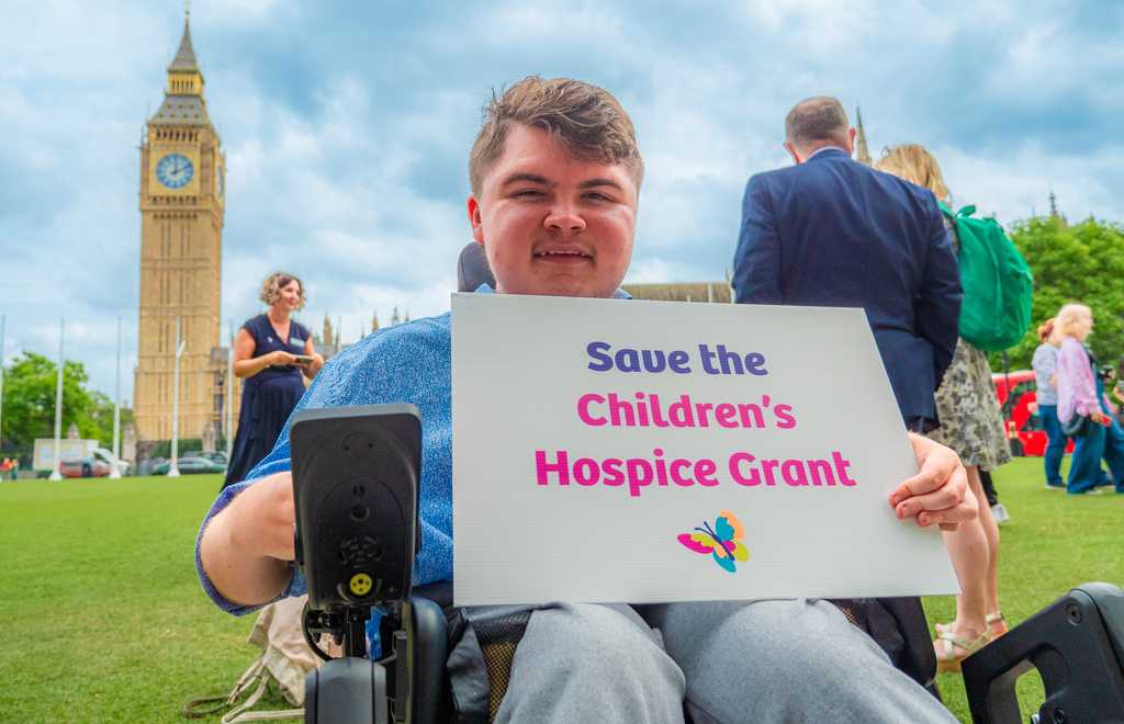 Photo of Liam at Westminster holding sign
