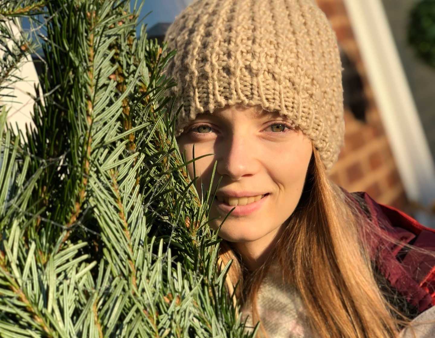 Photo of Izzy with a Christmas tree