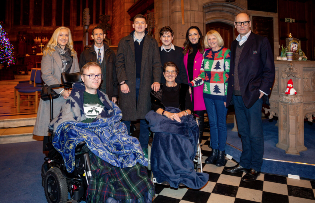 group of Claire House children, staff and Sally Nugent in a church.